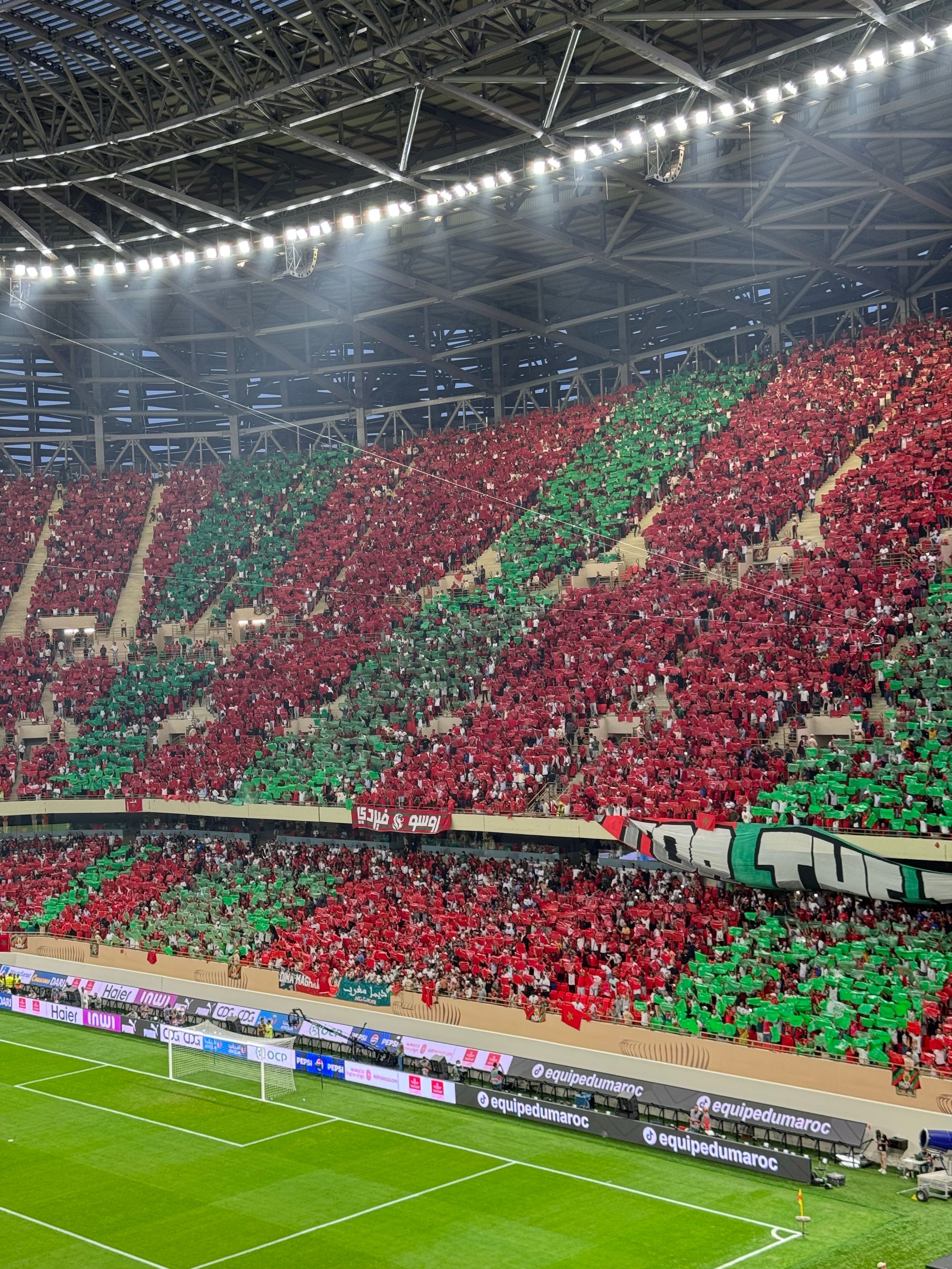 A vibrant red and green crowd display in a Moroccan stadium